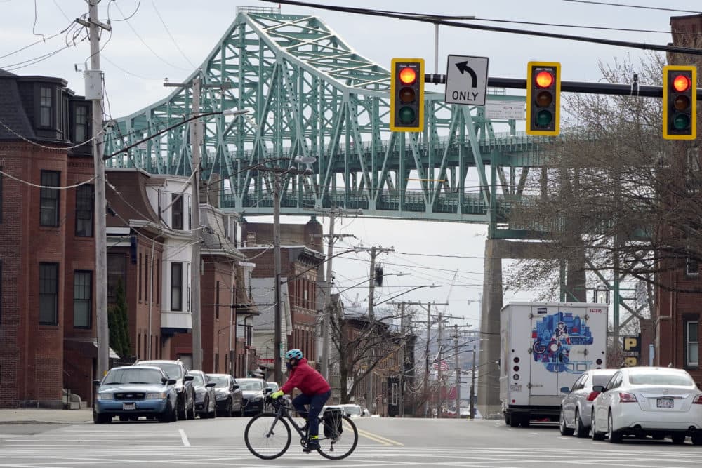 A cyclist rides along a street near the Tobin Memorial Bridge in Chelsea. (Steven Senne/AP)