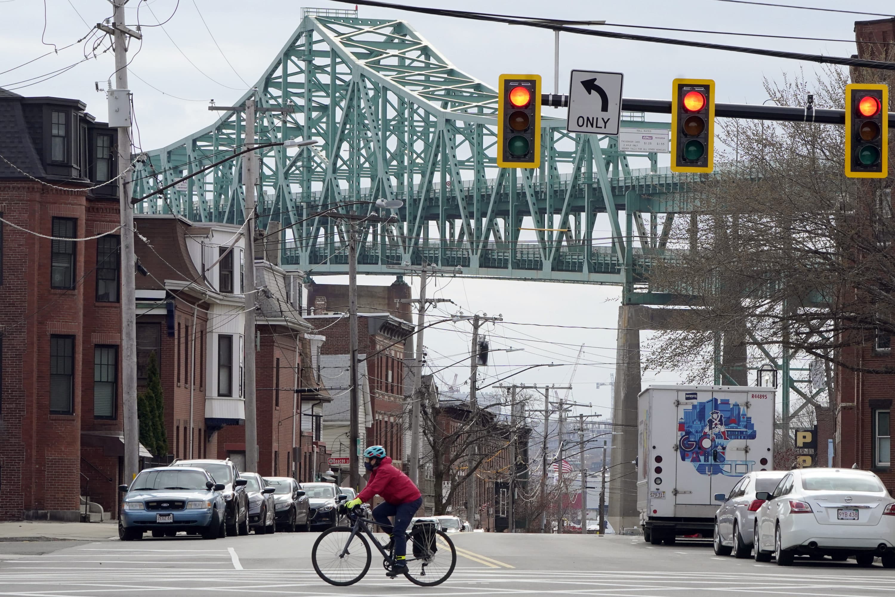 A cyclist rides along a street near the Tobin Memorial Bridge in Chelsea. (Steven Senne/AP)