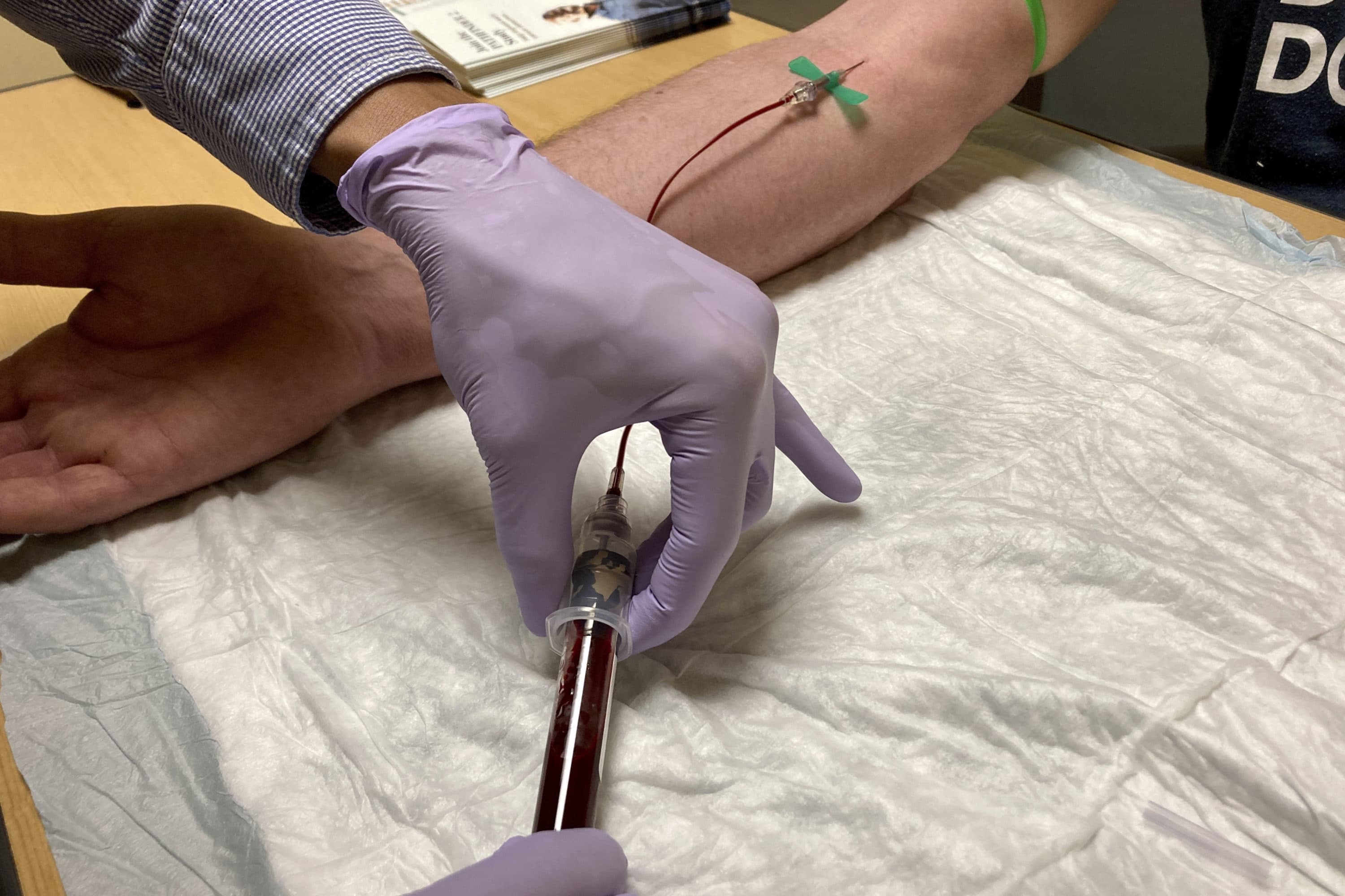 Jacob Marquez, a clinical research coordinator, draws blood from a clinical study participant (Gillian Flaccus/AP)