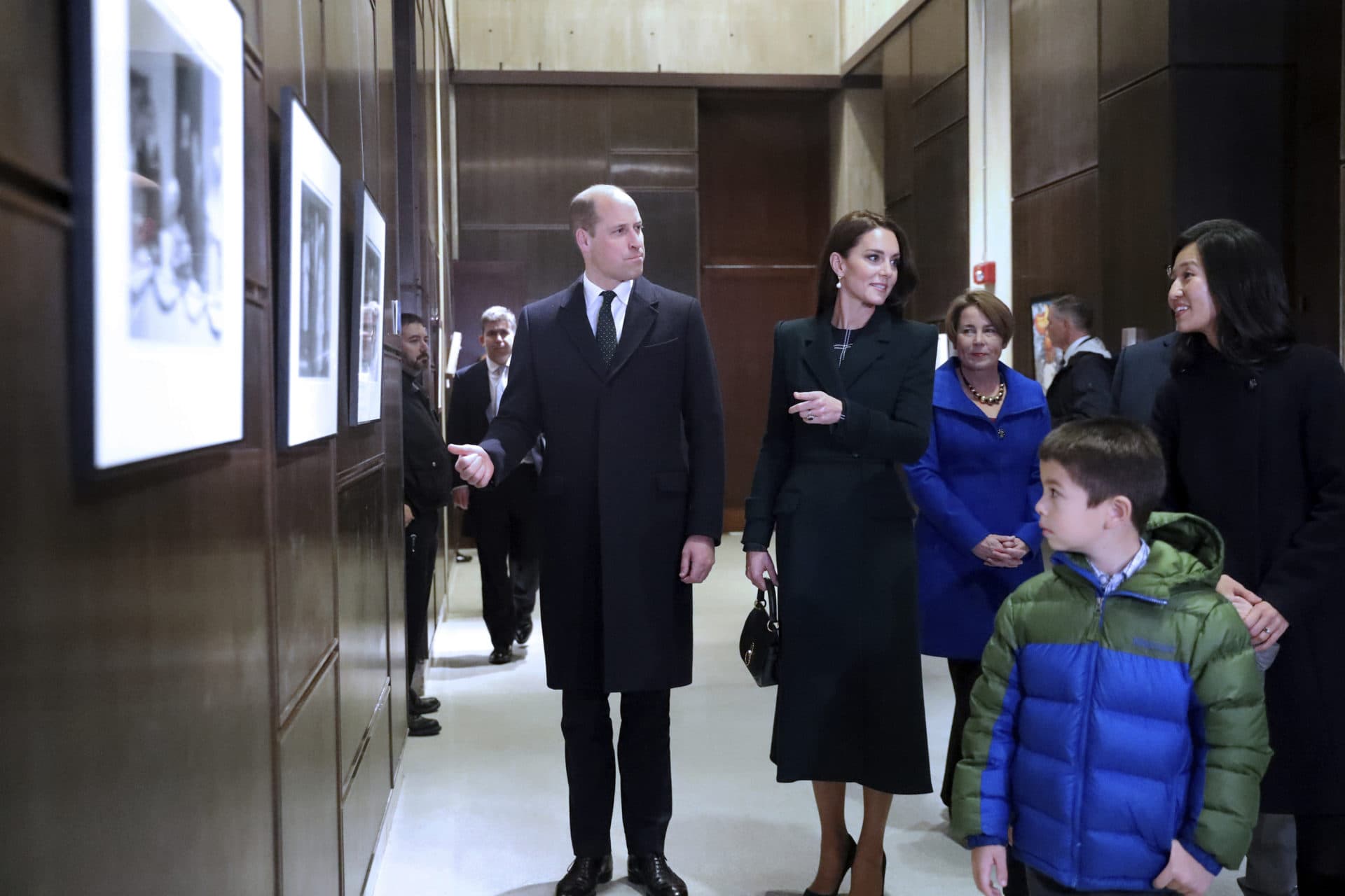 Boston Mayor Michelle Wu, right, and her family show photographs of Queen Elizabeth II's visit in 1976, during the visit of Britain's Prince William and Kate to Boston City Hall on Wednesday, Nov. 30, 2022, in Boston. (Nancy Lane/The Boston Herald via AP)