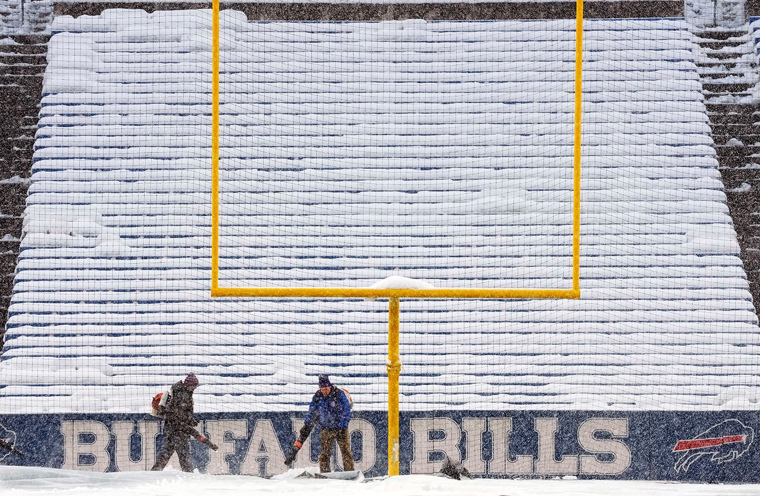Grounds crew work to clear snow off the field at Highmark Stadium before an NFL football game between the Buffalo Bills and the Miami Dolphins in Orchard Park, N.Y., Saturday, Dec. 17, 2022. (Gene J. Puskar/AP)