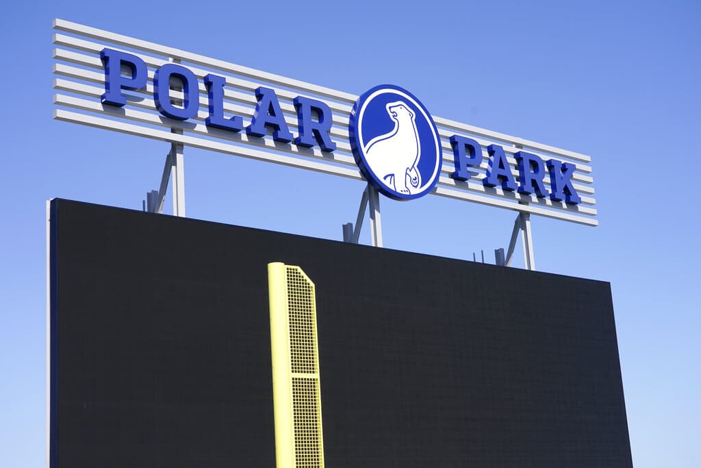 In this file photo, a sign stands above a large screen and the left field foul pole at Polar Park, Worcester Red Sox's Triple-A baseball stadium. The company that oversaw the construction of the minor league baseball park in Massachusetts has agreed to pay nearly $2 million to settle allegations, Dec. 22, 2022, that it failed to live up to its pledge of giving a certain portion of the work on the project to women- and minority-owned businesses. (Elise Amendola/AP File)