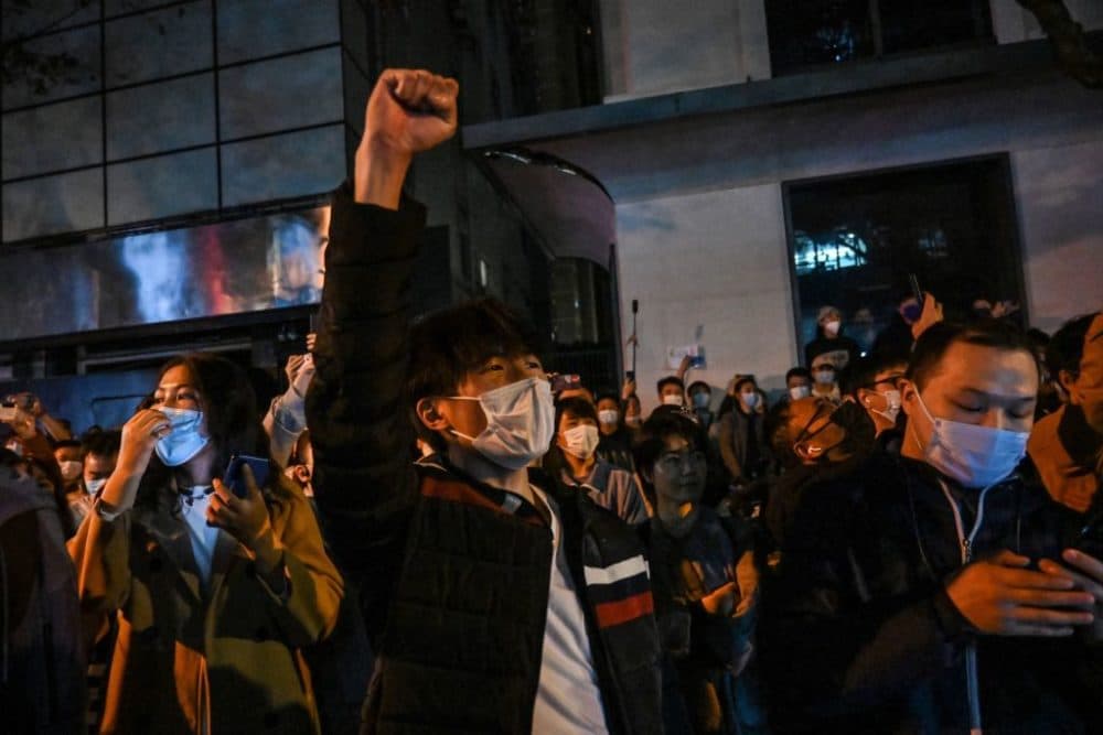 People sing slogans while gathering on a street in Shanghai on November 27, 2022. (HECTOR RETAMAL/AFP via Getty Images)