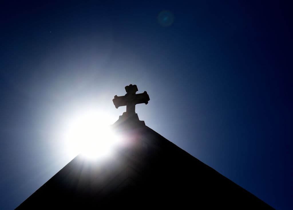 SANTA FE, NEW MEXICO - JUNE 21, 2020: The sun rises behind a stone cross atop the historic Cathedral Basilica of St. Frances of Assisi in Santa Fe, New Mexico. (Photo by Robert Alexander/Getty Images)