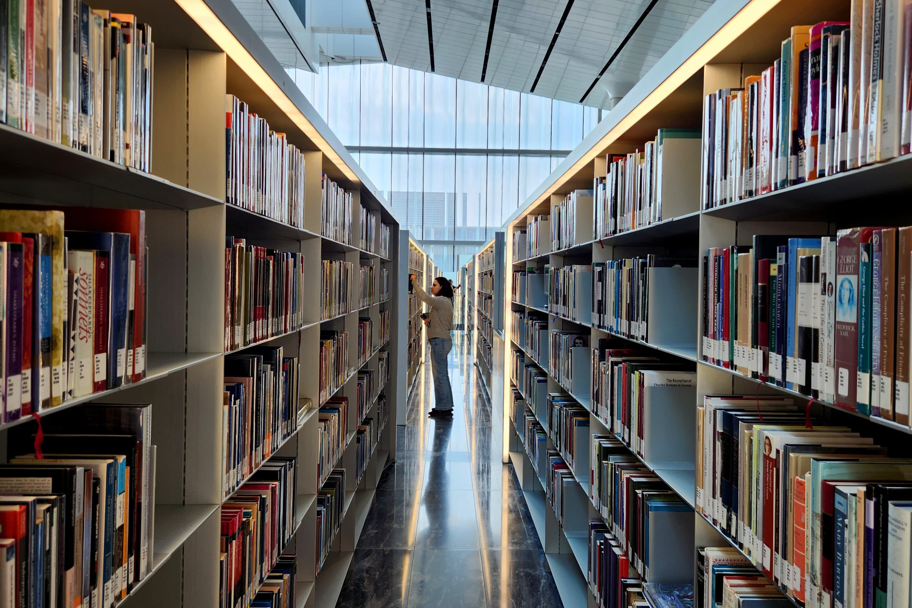 A woman picks a book from a shelf. (Fernando de Dios/Getty Images)