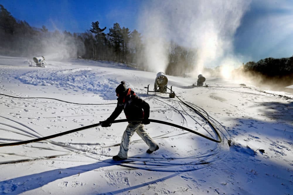 Snowmaker Lincoln Faria moves a water hose to prevent it from getting buried in the snow at the Blue Hills Ski Area in Canton, where snowmaking on the slopes began early in the morning to allow for skiing over the weekend on Dec. 14, 2017. (David L. Ryan/The Boston Globe via Getty Images)