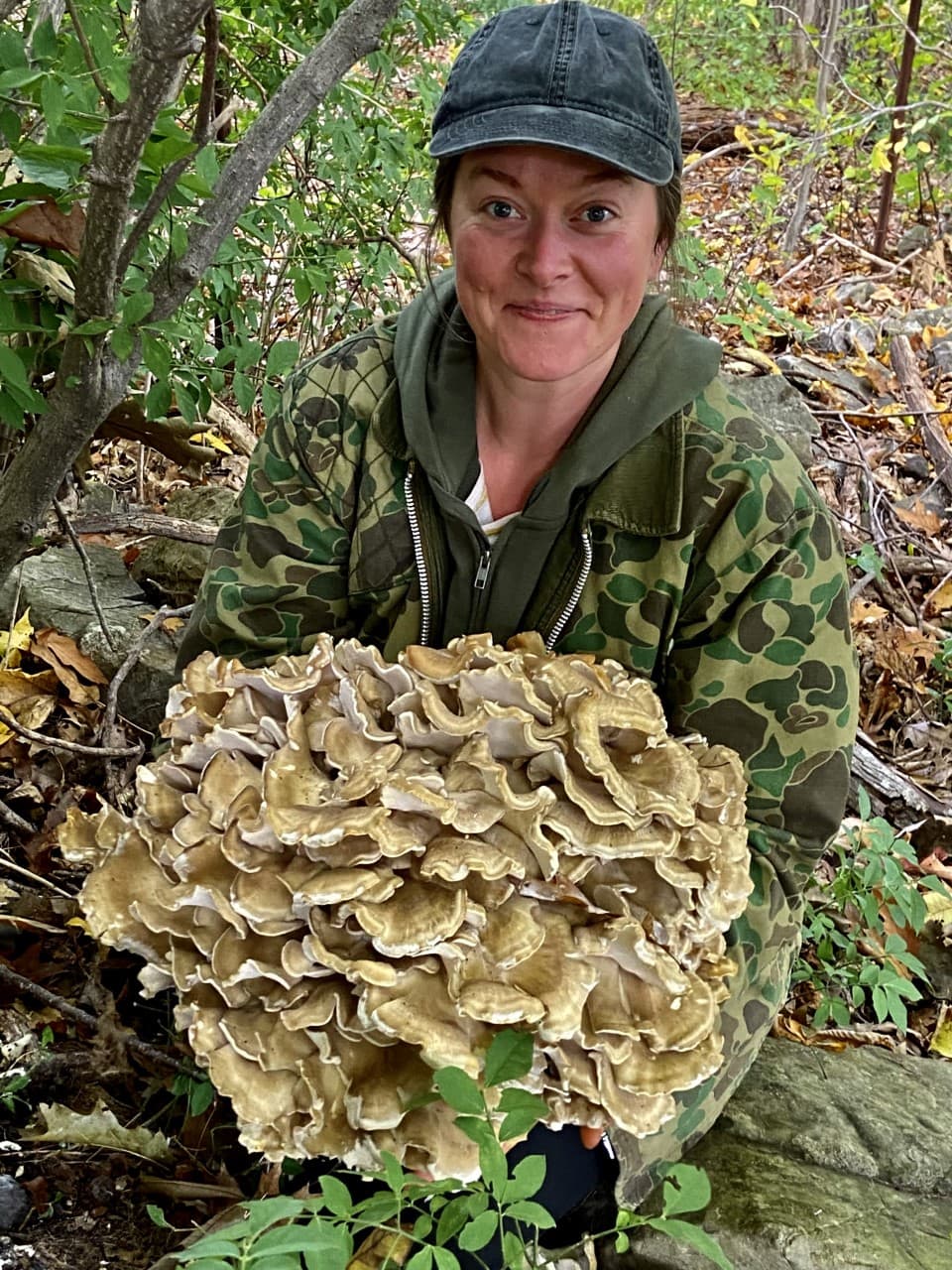 Jenna Rozzelle lifting 20 pounds of maitake mushrooms.  (Kathy Gunst/Here & Now)