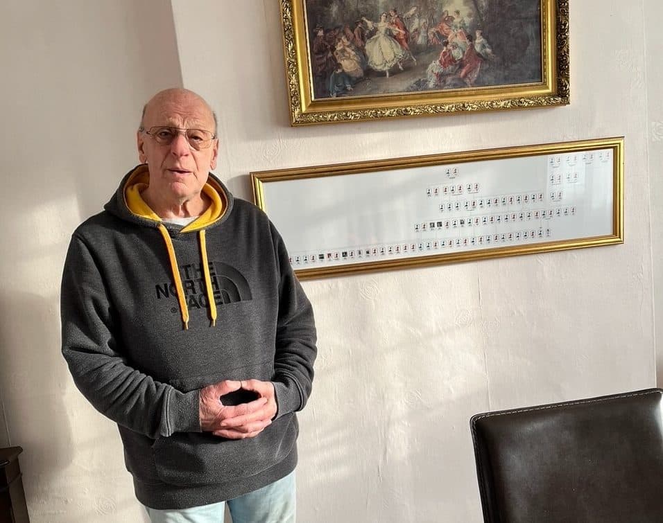 Holocaust survivor Jackie Young standing in front of the the family tree showing the relatives he discovered after his DNA analysis. (Courtesy of Jackie Young)
