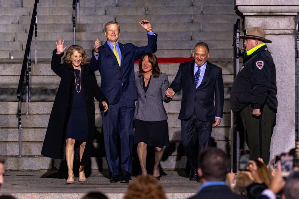 First Lady Lauren Baker, Gov. Charlie Baker, Lt. Gov. Karen Polito and Steve Rodolakis celebrate as they arrive to the bottom of the Massachusetts State House steps during the ceremonial lone walk. (Jesse Costa/WBUR)