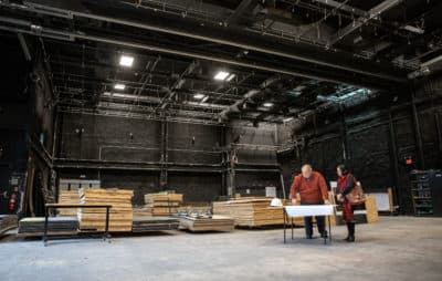 David Altshuler, the founder of Arrow Street Arts, and Cambridge Community Foundation president Geeta Pradhan look over plans for the new theater space at 2 Arrow St. in Cambridge. (Robin Lubbock/WBUR)