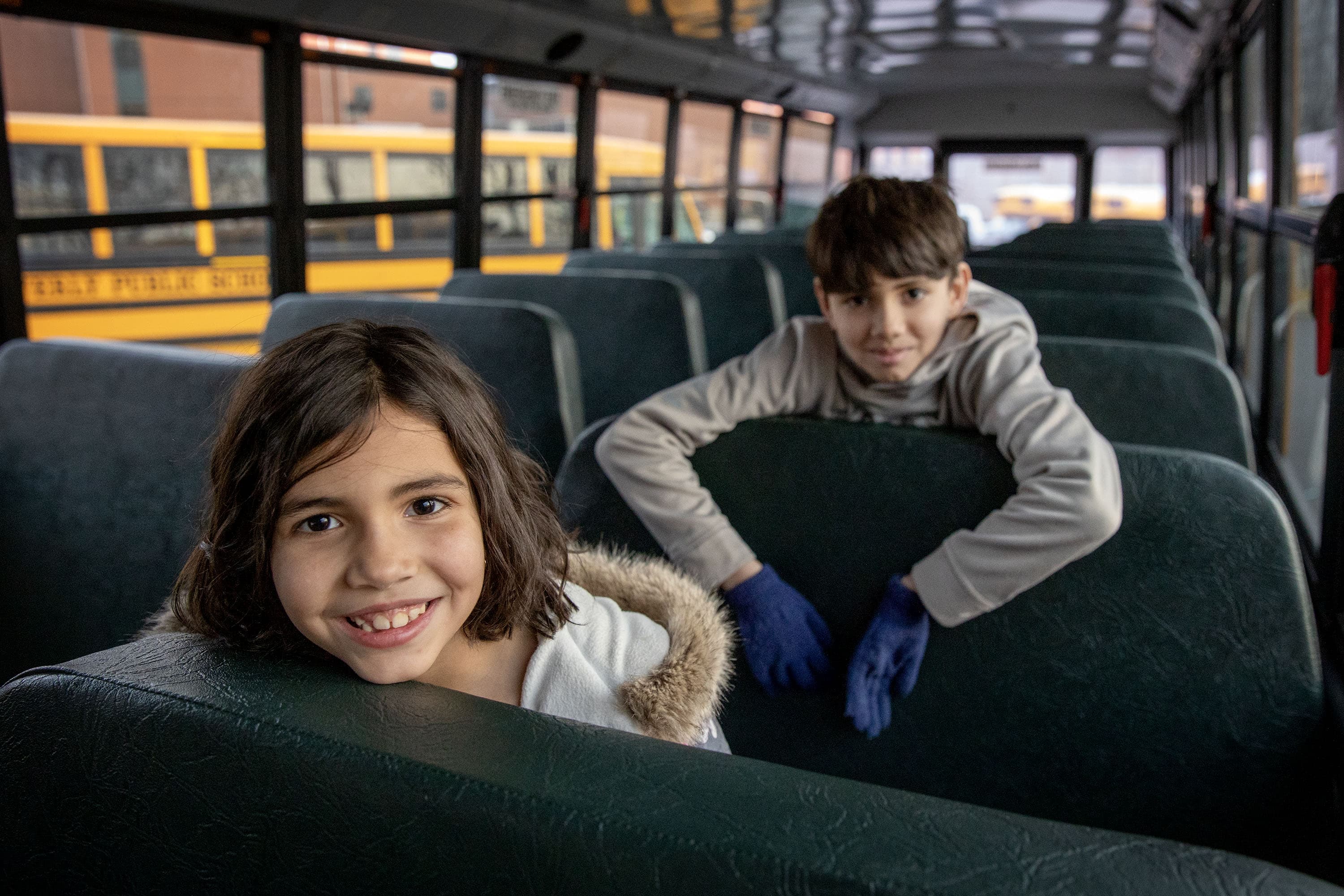 Cove Elementary students Angelina and Kenneth Denis aboard an electric school bus in Beverly, Mass. (Robin Lubbock/WBUR)