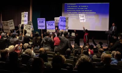 Protestors confront Cambridge city officials at a meeting to discuss the fatal police shooting of Arif Sayed Faisal. (Robin Lubbock/WBUR)