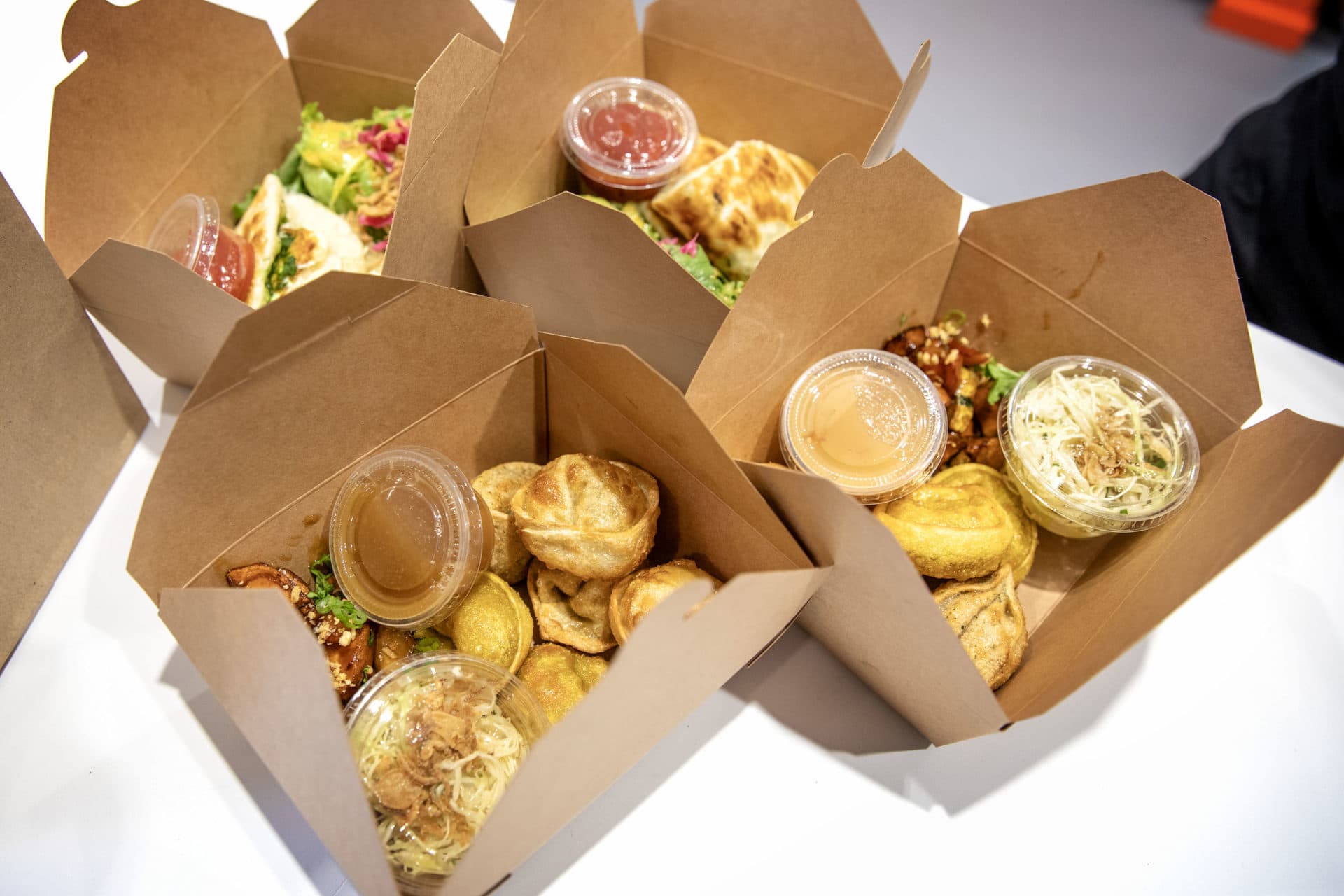 Dumplings, pancakes and vegetables boxed up and ready to collect at Mei Mei's Dumpling Factory and Cafe. (Robin Lubbock/WBUR)