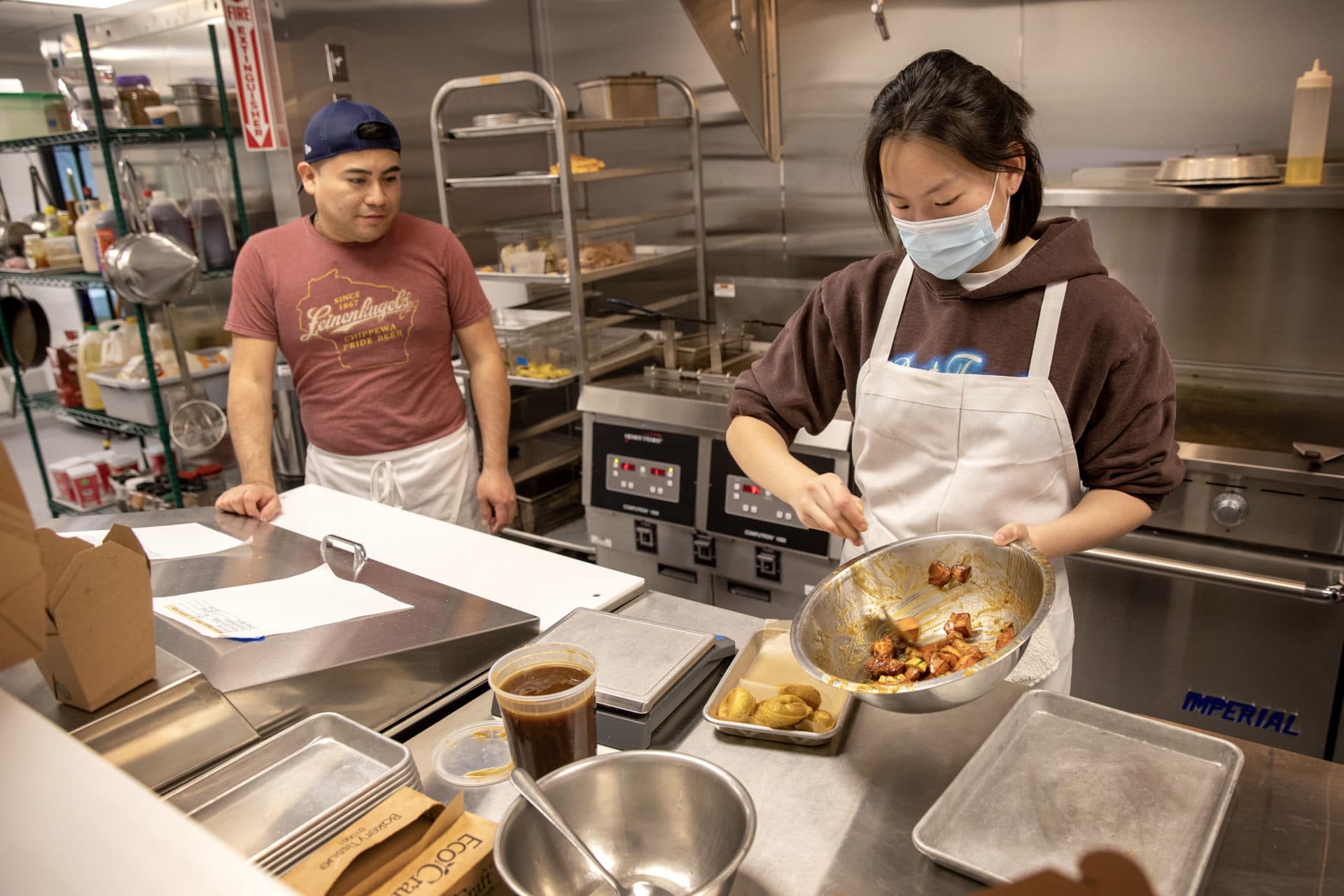 Line cooks Walter Perez and Libby Jelley work on orders in the kitchen at Mei Mei Dumpling Factory and Cafe. (Robin Lubbock/WBUR)