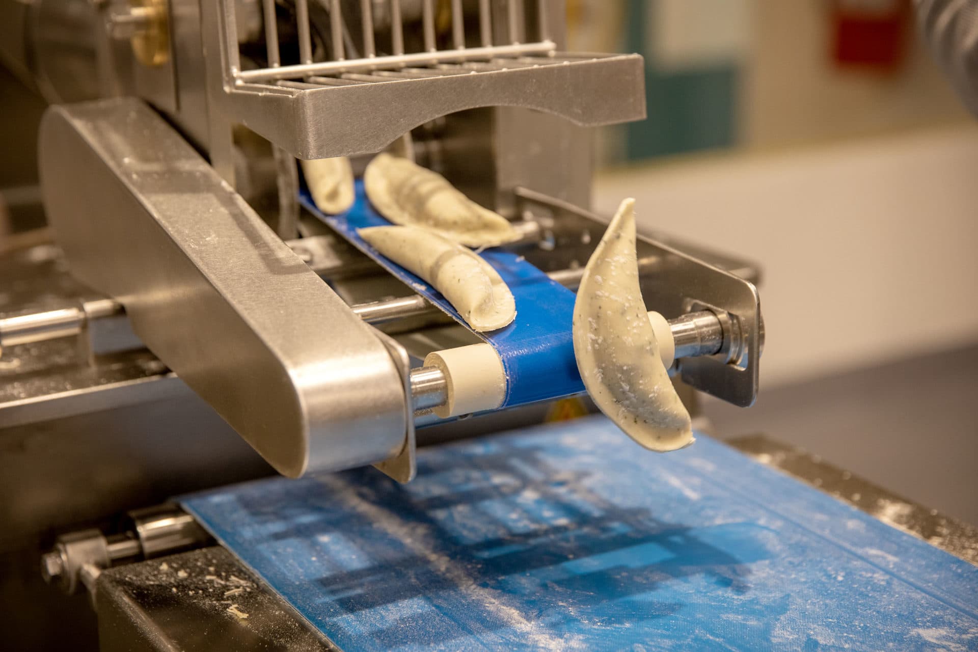 Newly made dumplings roll off the dumpling machine at Mei Mei in Boston. (Robin Lubbock/WBUR)