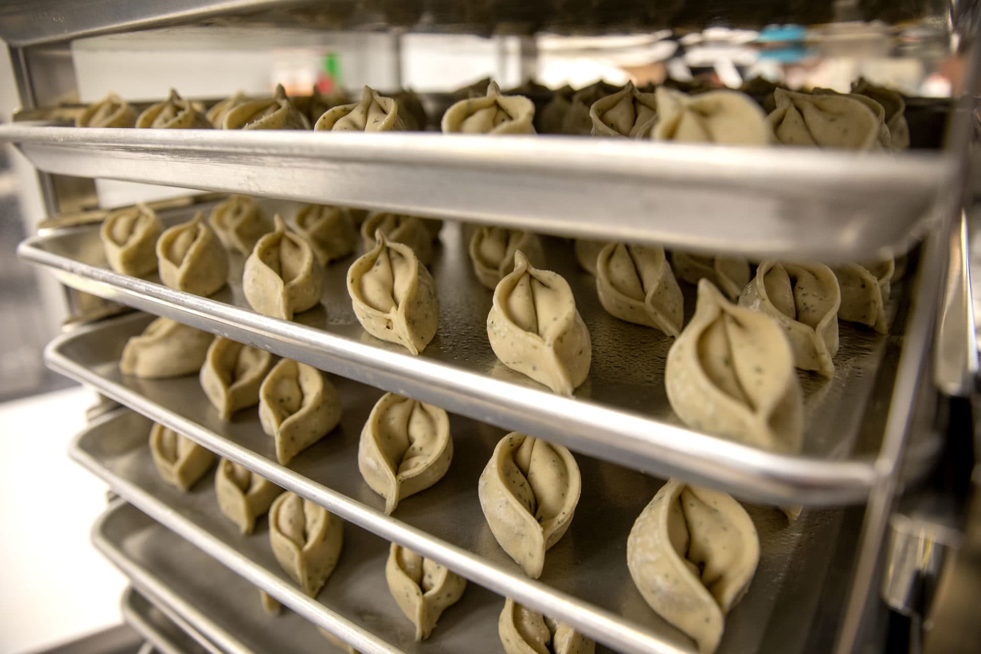 Dumplings at Mei Mei's Dumpling Factory wait on trays to go into the oven. (Robin Lubbock/WBUR)