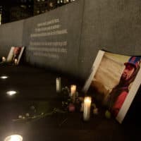 Candles and flowers left at the Embrace sculpture on Boston Common in memory of Tyre Nichols. (Robin Lubbock/WBUR)