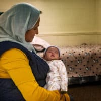 Gulalai holds her infant Nadya, her ninth child and the first U.S. citizen in the family. (Jesse Costa/WBUR)