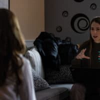 Laura Polizoti, a family intervention specialist at Youth Villages, discusses strategies with 12-year-old Haley for managing her anger. (Jesse Costa/WBUR)