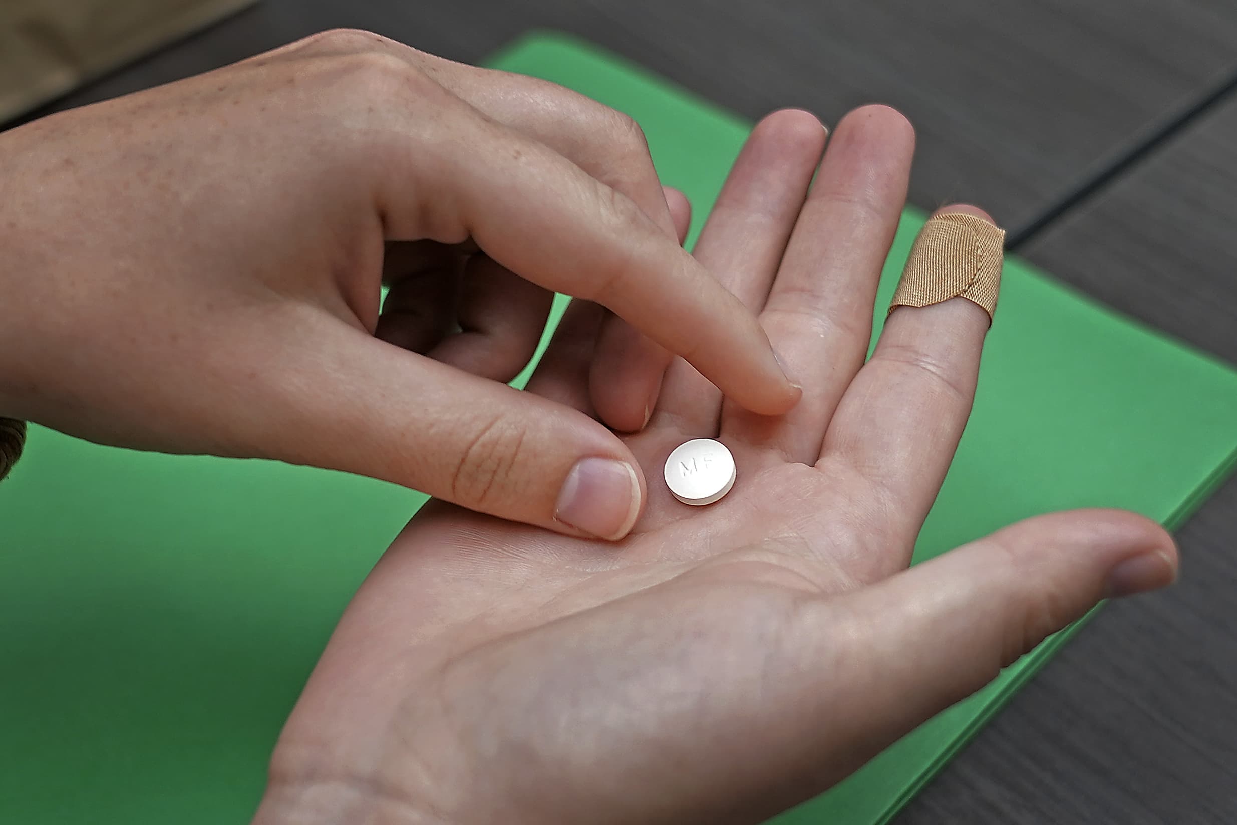 A woman prepares to take the first of two pills taken for a medical abortion during a visit to a Planned Parenthood clinic Wednesday, Oct. 12, 2022, in Kansas City, Kan. (Charlie Riedel/AP)