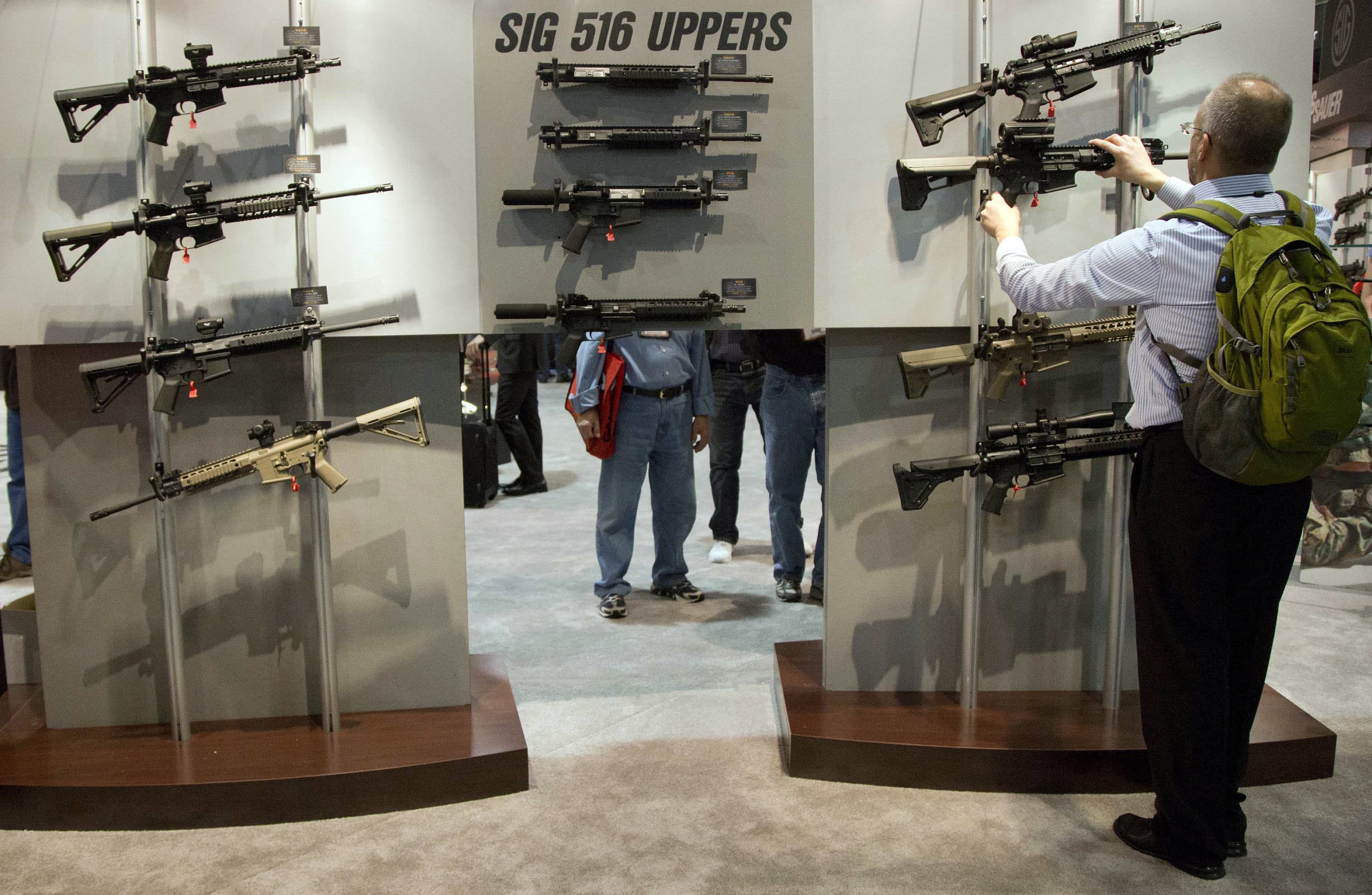 A convention attendee looks through a display of Sig Sauer semiautomatic rifles during the 35th annual SHOT Show, Tuesday, Jan. 15, 2013, in Las Vegas. (Julie Jacobson/AP)
