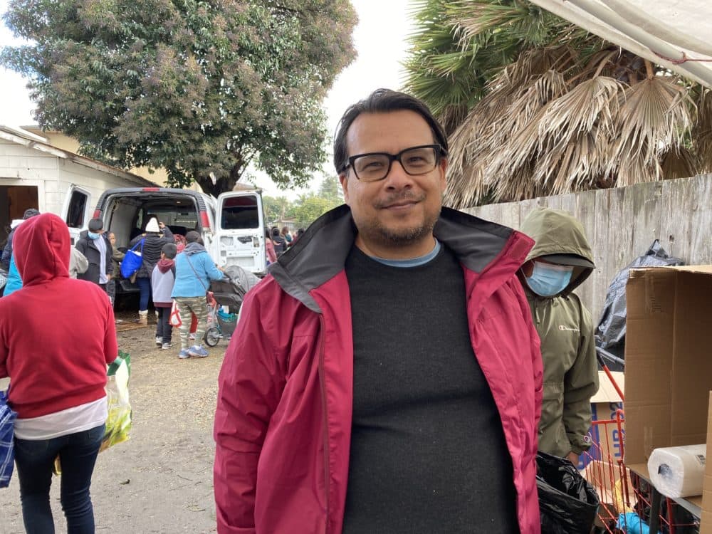 Center for Farmworker Families board member Eloy Ortiz helps distribute groceries at a food distribution event in Watsonville, CA on January 13, 2023. The farmworkers who harvest the nation's food are paid so little that they can't always afford to eat it themselves, and in California, extreme weather fueled by climate change. (Teresa Cotsirilos/FERN)