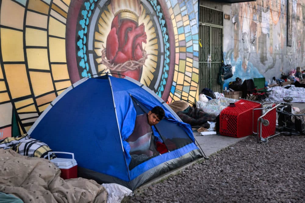 Immigrants awake after spending the night sleeping outside a migrant shelter on January 9, 2023 in El Paso, Texas. President Joe Biden visited El Paso on January 8, his first visit to the border since he became president two years before. (John Moore/Getty Images)