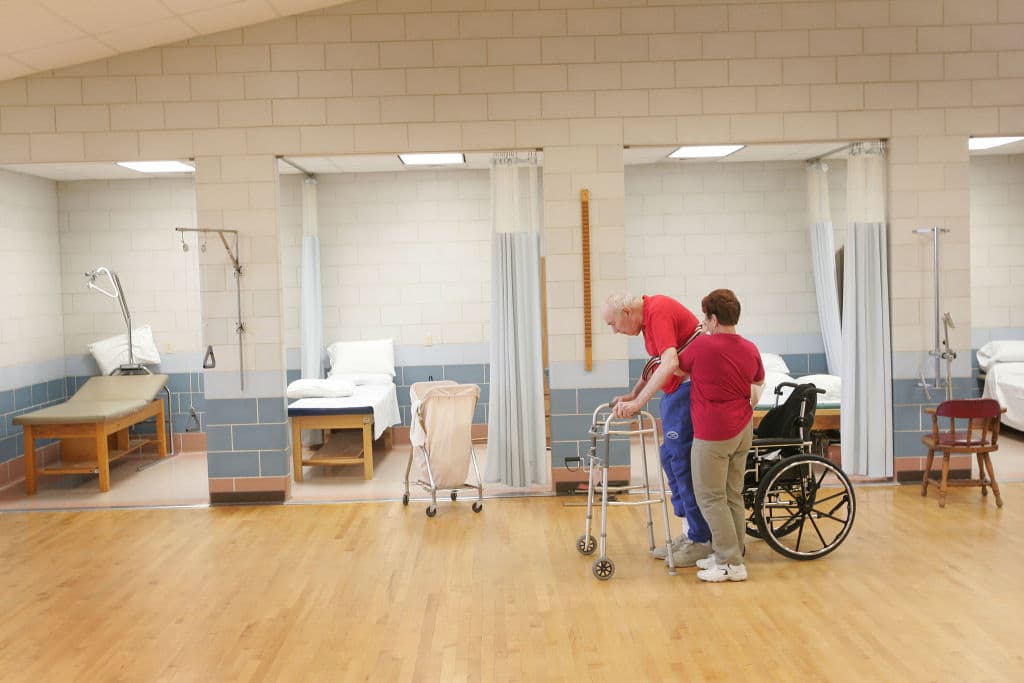 Shirley Gooding, a physical Therapy Aid, helps William Rexroat, a WWII Navy veteran exercise during a physical therapy session at the Quincy Veterans Home February 17, 2005 in Quincy, Illinois. The home, with its 683 beds, is the largest and oldest of four veteran's nursing homes in Illinois. The federal budget, as currently proposed by the Bush Administration, seeks to reduce the number of residents nationwide in these facilities from 38,000 to 33,000. (Photo by Scott Olson/Getty Images)