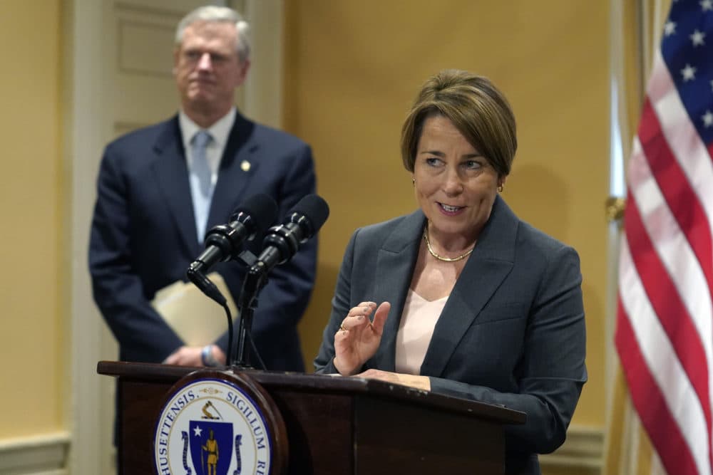 Massachusetts Democratic Attorney General Maura Healey, right, speaks to reporters as Republican Mass. Gov. Charlie Baker, behind, looks on during a news conference on Nov. 9, 2022, at the State House in Boston. (Steven Senne/AP)