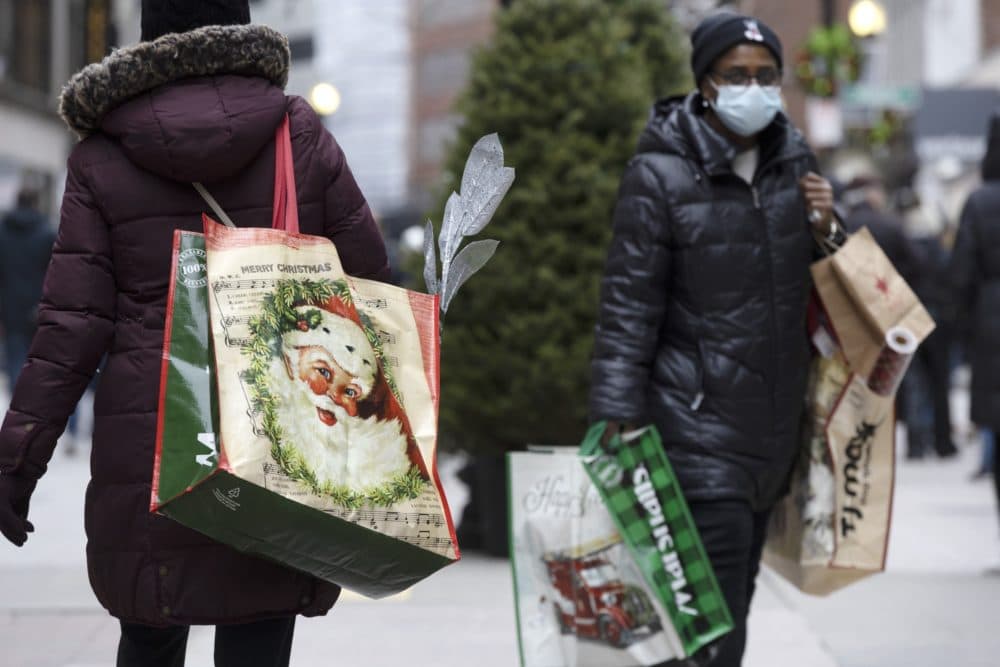 People carry shopping bags in December of 2022 at Downtown Crossing in Boston. (Michael Dwyer/AP)
