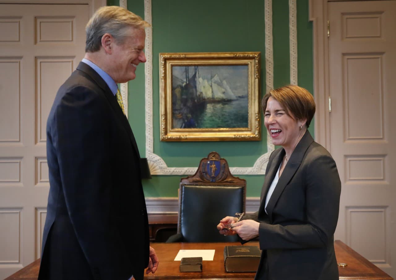 Gov. Charlie Baker and Gov.-elect Maura Healey share a laugh during an exchange of symbols at the Massachusetts State House. (Nancy Lane/Boston Herald via pool)