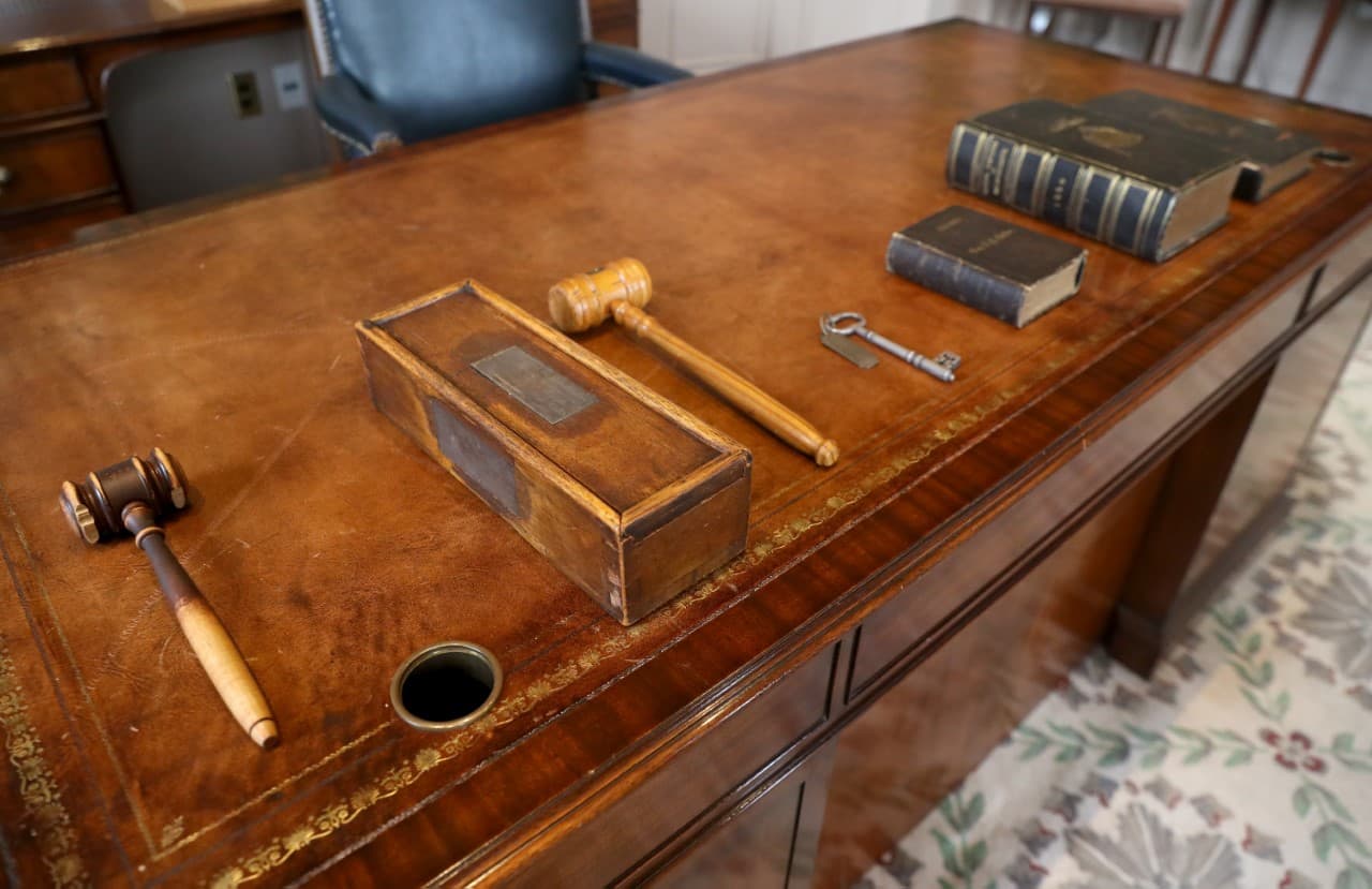 A series of symbolic items including a bible dating to the 1800s and a gavel made from the white oak frame of the U.S.S. Constitution sit on a desk before Massachusetts Gov. Charlie Baker presented them Gov.-elect Maura Healey, at the State House in Boston. (Nancy Lane/Boston Herald via pool)