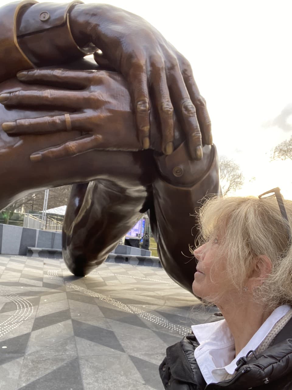 Host Robin Young looks at &quot;The Embrace&quot; where the hands appear to form a heart. (Robin Young/Here &amp; Now)