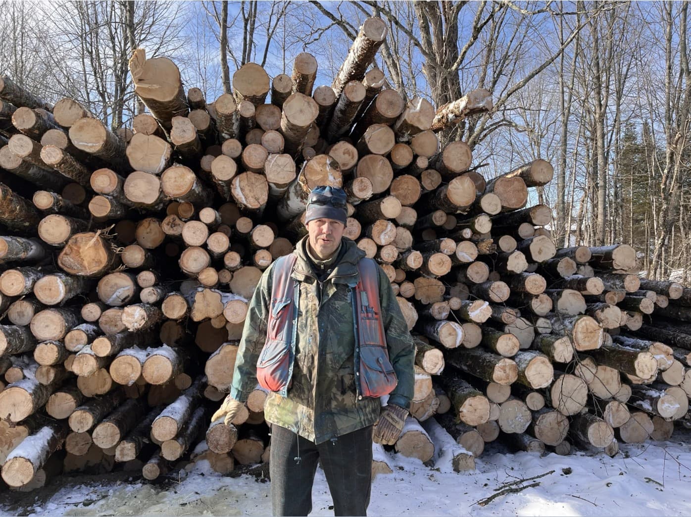 Forester David Senio, standing in front of a pile of balsam fir logs, said responsibly managing forests can make them healthier in the long run. (Henry Epp/Vermont Public)