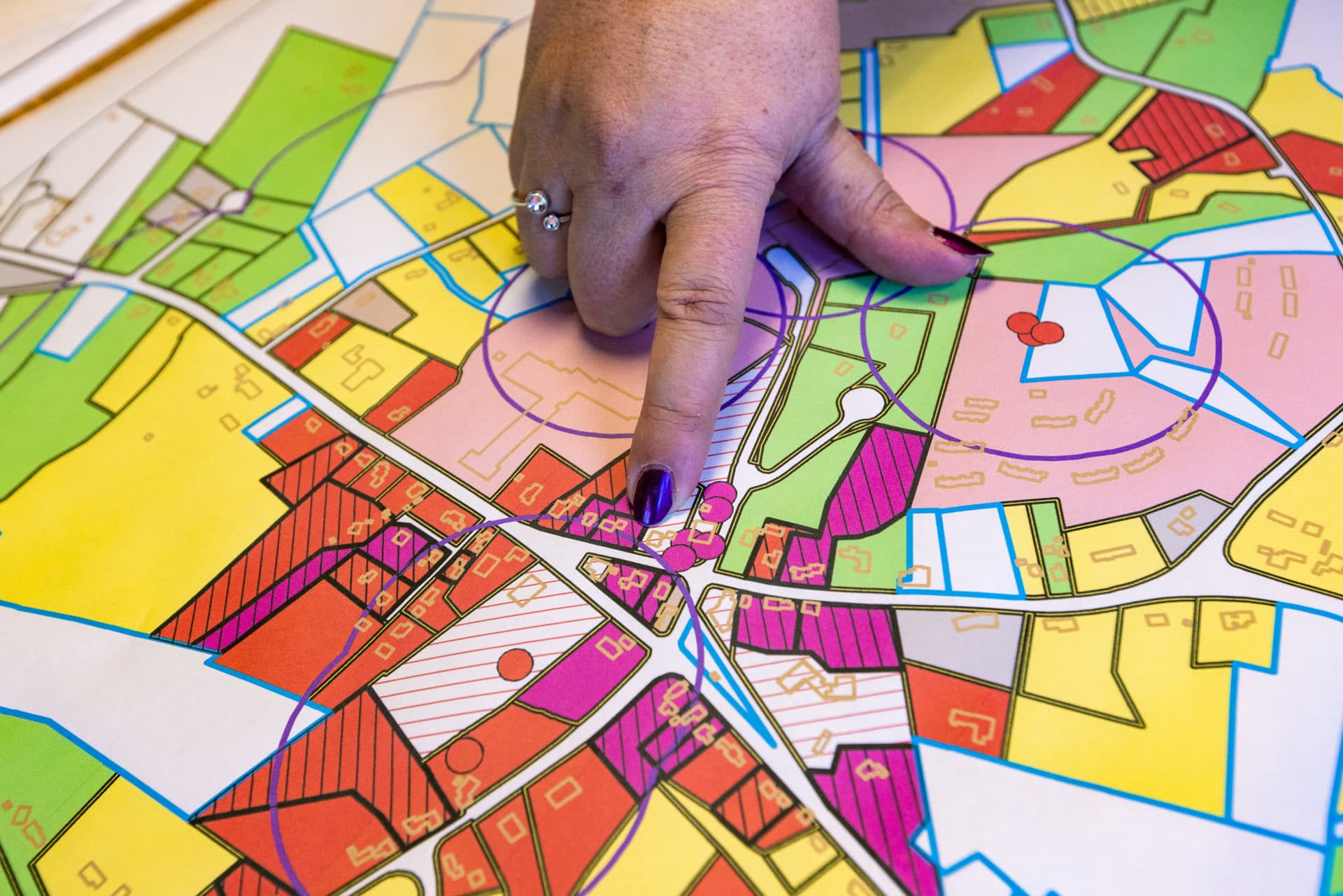 Town Administrator Denise Dembroski, points out on a map, the origin of the PFAS contamination at the old fire station across the street from the town offices. (Jesse Costa/WBUR)