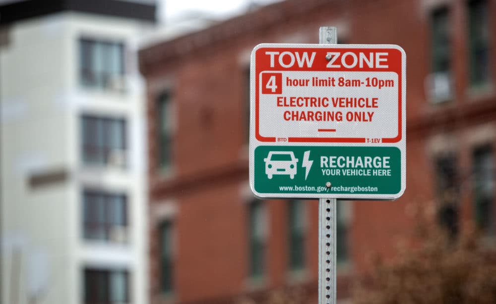 An electric car charger sign in a parking lot in Roxbury says electric vehicle charging only (Credit: Robin Lubbock/WBUR)