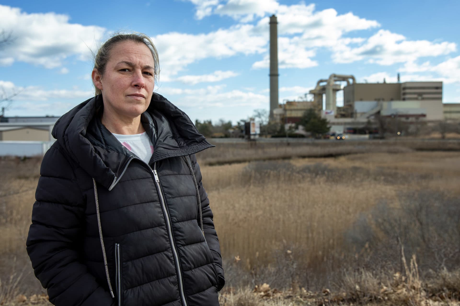 Jackie Mercurio, a Saugus resident and member of Alliance for Health and the Environment, stands in Rumney Marsh near the WIN Waste incinerator and landfill. (Credit: Robin Lubbock/WBUR)