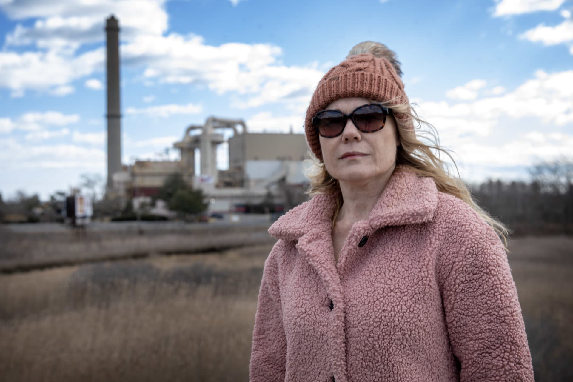 Debra Panetta, vice chairman at Saugus Board of Selectmen, stands in Rumney Marsh near the WIN Waste incinerator. (Credit: Robin Lubbock/WBUR)