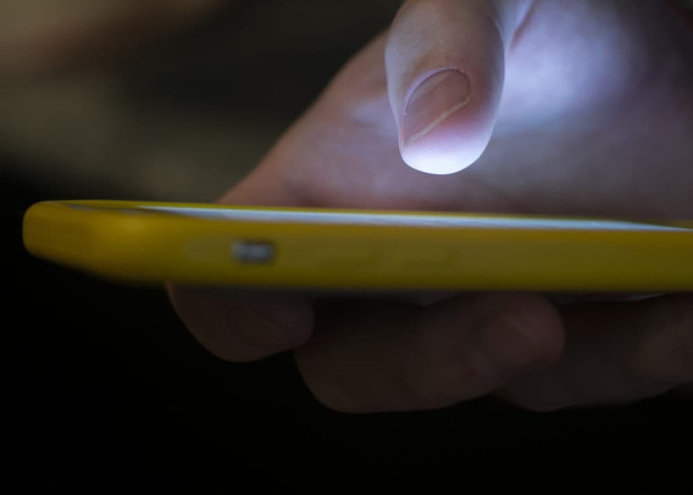 A man uses a cell phone. (Jenny Kane/AP)