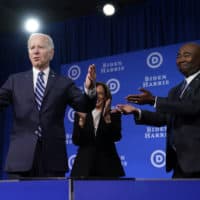 President Joe Biden and Vice President Kamala Harris stand on stage with DNC chair Jaime Harrison at the Democratic National Committee winter meeting on Feb. 3 in Philadelphia. (Patrick Semansky/AP)