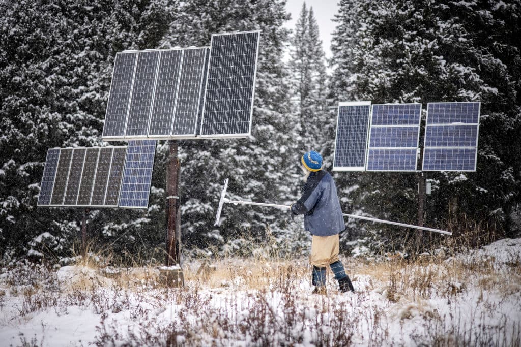 Billy Barr clears snow off the several solar panels that power his home in Gothic, Colorado. Barr has kept detailed snow reports, weather reports, and animal sightings for decades, and his information has become a resource for climate scientists studying the region. (Chet Strange for The Washington Post via Getty Images)