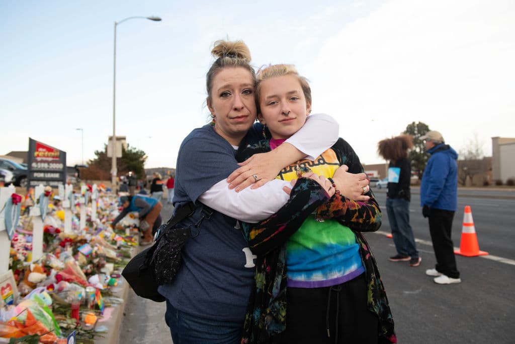 Layla Aronow poses with child Kai Aronow, 12, who is transgender, at the memorial near Club Q in Colorado Springs, United States on Nov. 23, 2022. While posing for the photograph, someone in a passing car yelled out, "Faggot!" Kai calmly stated after, "It definitely hurts, but it doesn't have the power they want it to have. I'm just glad there are so many people who care." (Ross Taylor for The Washington Post via Getty Images)