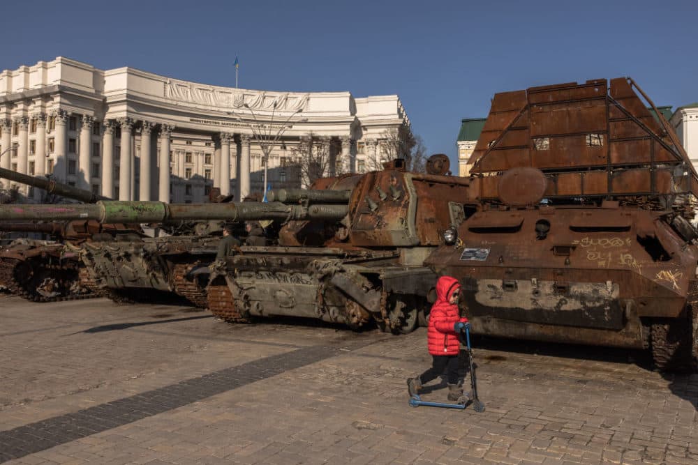 A child walks past destroyed Russian military vehicles on display in Mykhailivskyi Square, on February 23, 2023 in downtown Kyiv, Ukraine. of regular air strikes. (Roman Pilipey/Getty Images)