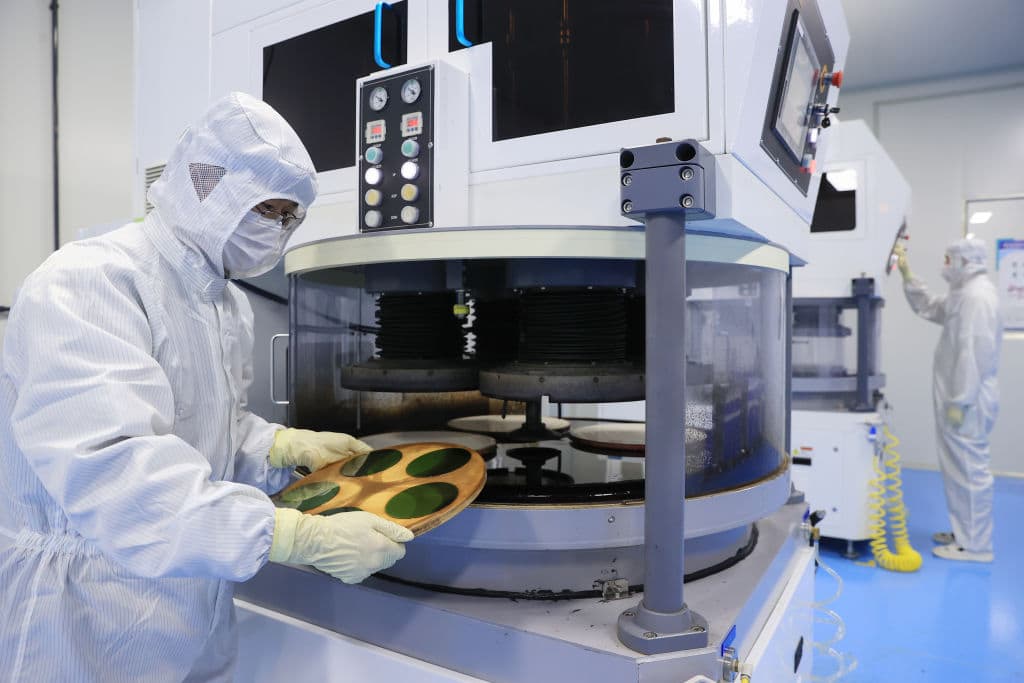 An employee works on the production line of silicon carbide (SiC) wafer at a factory on May 31, 2022 in Dongying, Shandong Province of China. (Photo by Zhou Guangxue/VCG via Getty Images)