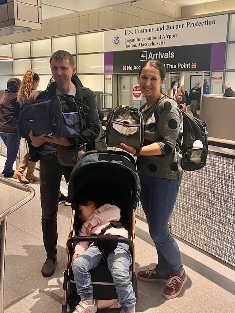 A tired but hopeful Vlad Kostochka, Ira Ostapenko, and their daughter Iryna Ostapenko at Logan International Airport. (Image via Welcome NST)