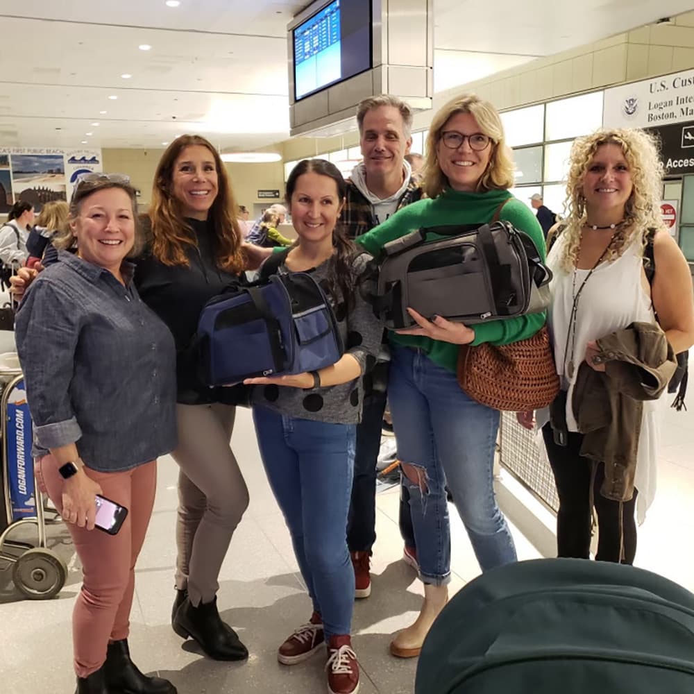 Team Ira at Logan International Airport right after Ira and family arrived. Names (from left): Shannon Kelley, Gina Ashe, Ira Ostapenko, Rob Greayer, Rochelle Greayer and Jen Sundeen with Cats (Kosik and Mikha in the carriers). You can see the hood of the stroller where Iryna is asleep. Shannon, Gina. Rob, Rochelle and Jen are NST team members from Harvard MA. (Image via Welcome NST)
