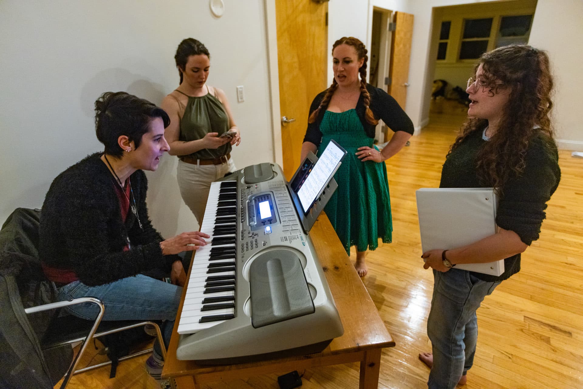 Composer Melissa Carubia directs the cast through one of the numbers in “T: An MBTA Musical” during a rehearsal at The Center for Arts at the Armory in Somerville. (Jesse Costa/WBUR)