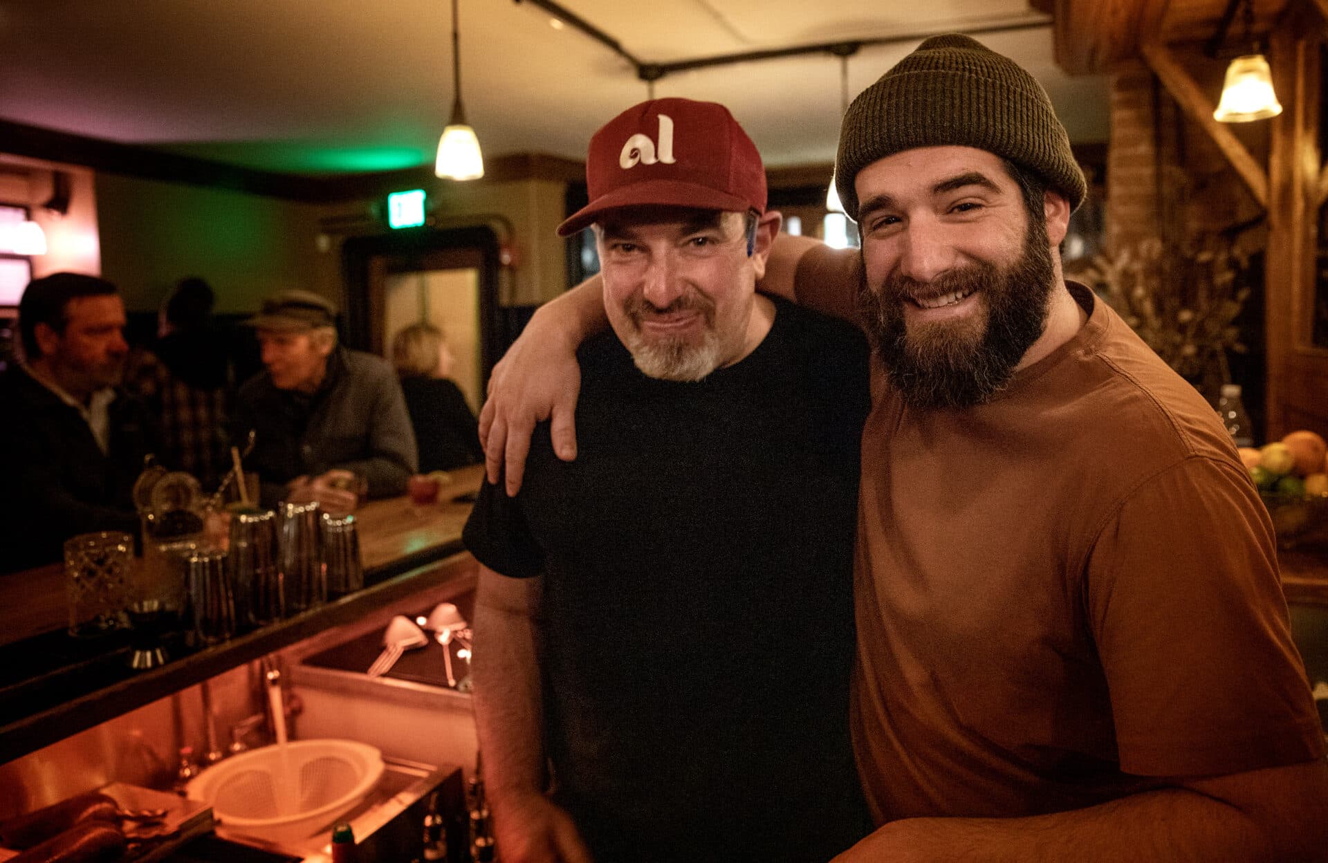 Barman Liam Davenport and manager Alexander Sirigu pause for a photo on a busy evening at Atwood's in Cambridge. (Robin Lubbock/WBUR)