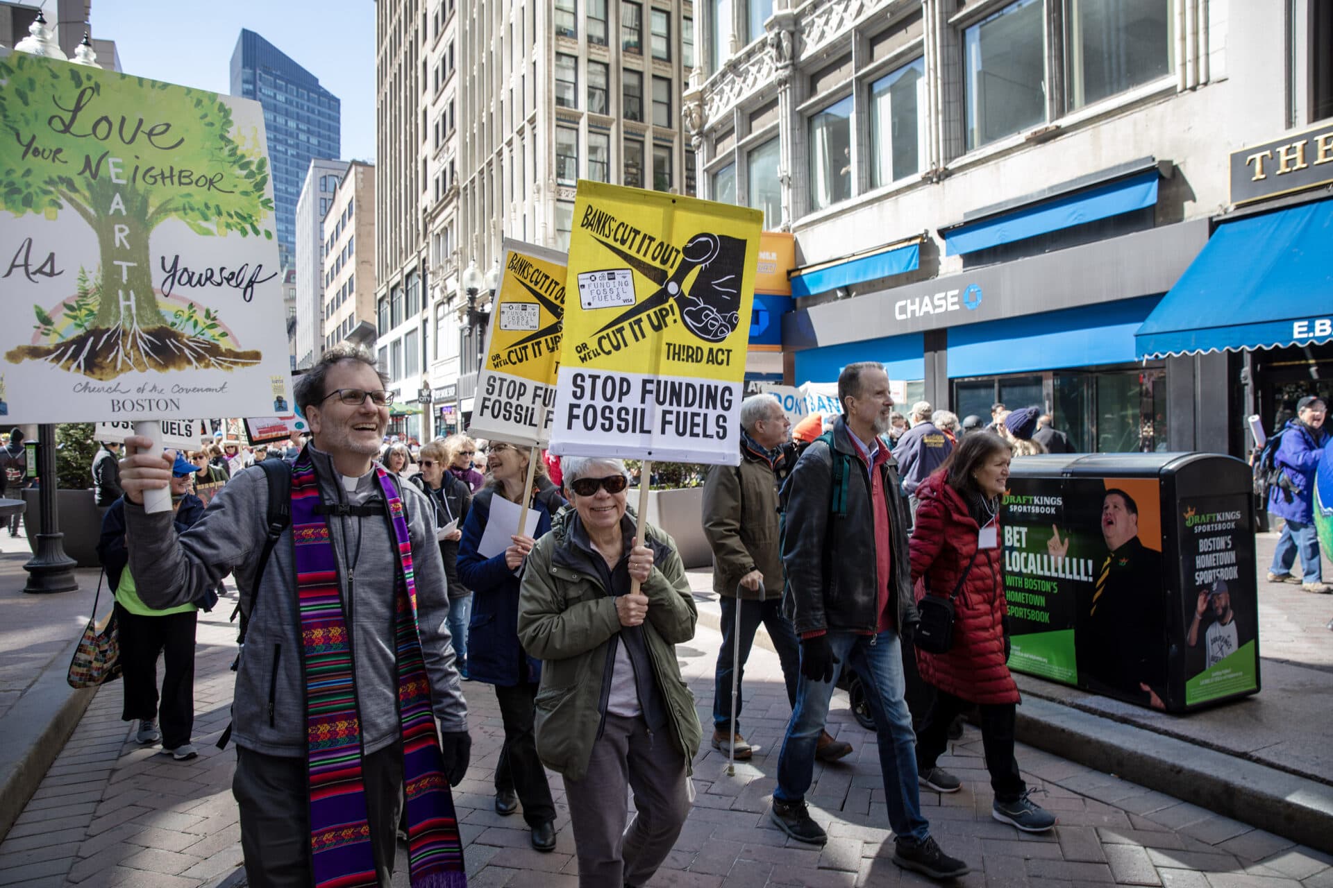 Protesters march past Chase Bank in downtown Boston, calling on banks for stop funding fossil fuel projects. (Credit: Robin Lubbock/WBUR)