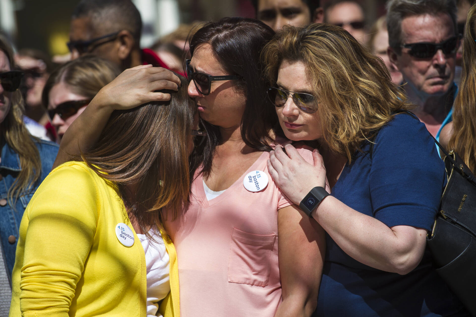 Three women embrace during a moment of silence on April 15, 2015, marking two years since the bombings. (Jesse Costa/WBUR)